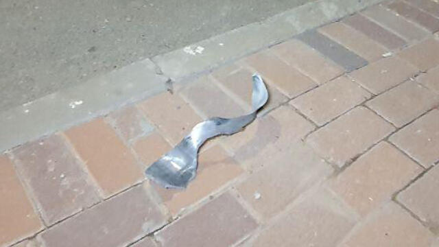 Twisted debris lies on the ground outside the Sderot home hit by Gaza rocket fire Friday night