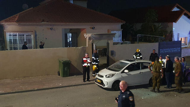 Security personnel outside the Sderot home hit by rocket fire Friday night