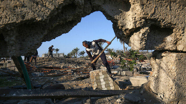 Palestinians inspect the damage after an Israeli strike (צילום: AFP) Palestinians inspect the damage after an Israeli strike