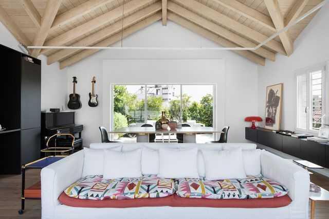 В этой гостиной прекрасно "уживаются" шкафы из IKEA, старый диван и дизайнерские аксессуары. Фото: Ширан Кармель