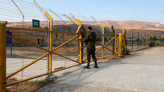 Israeli soldier closing the gate into the Island of Peace
