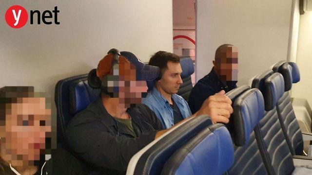 Бурков на борту самолета в окружении федеральных агентов США.