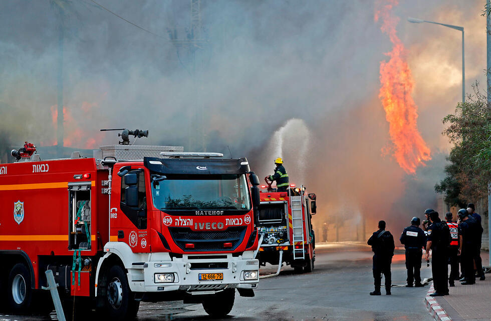 Пожарные возле горящего завода. Фото: AFP