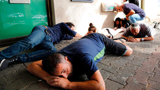 Israeli citizens sheltering themselves during a rocket attack