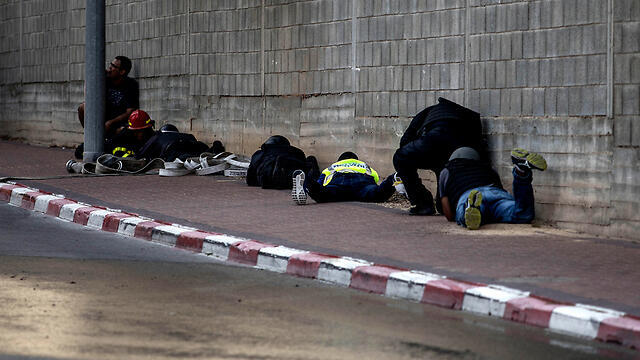 Israelis take cover from Gaza rocket fire in Sderot (צילום: AP) Israelis take cover from Gaza rocket fire in Sderot