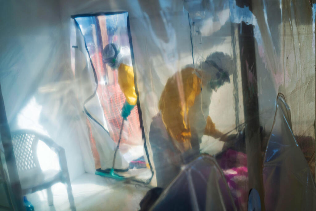 Christian Lindmeier tells ynet Global: 'We are fighting an infodemic at the same time we are fighting an epidemic or a pandemic' (Photo: AP) תמונות השנה AP מטפלים בחולה אבולה בבידוד ב קונגו