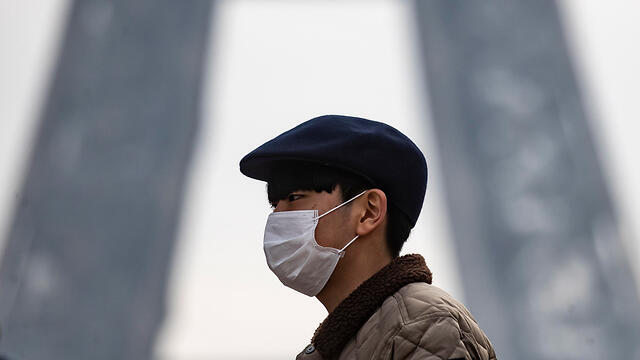 На улицах Китая все ходят в масках. Фото: EPA