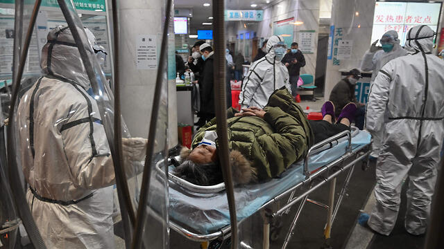 Прием больного с подозрением на коронавирус в больнице в Уханe. Фото: AFP (צילום: AFP) Прием больного с подозрением на коронавирус в больнице в Уханe. Фото: AFP