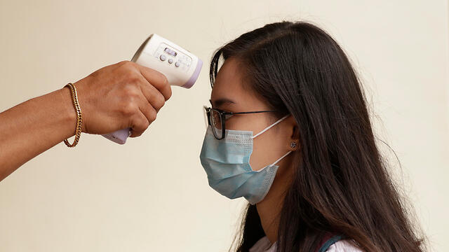  Измерение температуры инфракрасным термометром. Фото: AP