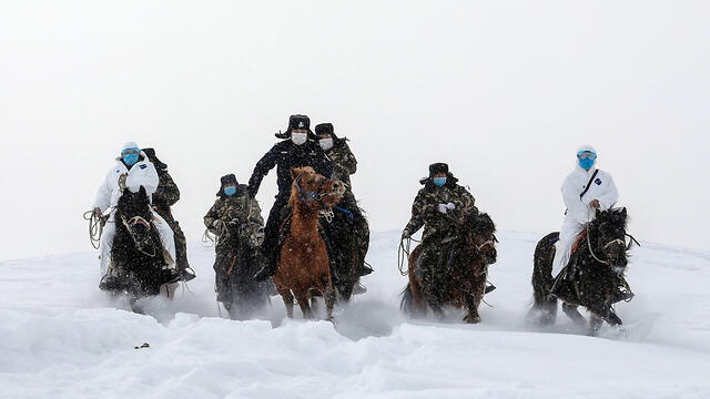 Китайская полиция сопровождает медиков при проверке в округе Алтай. Фото: EPA (צילום: AFP) Китайская полиция сопровождает медиков при проверке в округе Алтай. Фото: EPA