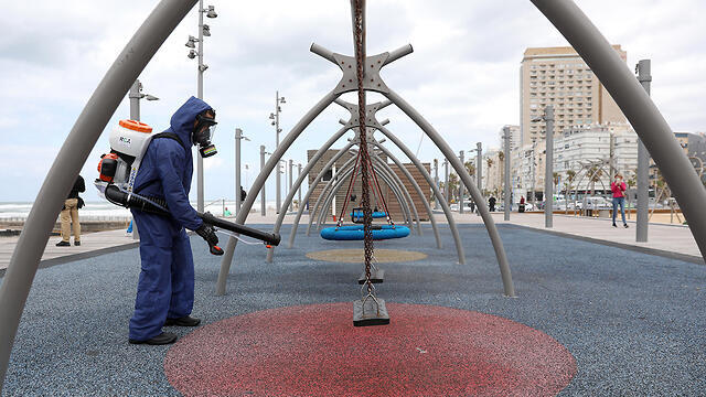 Дезинфекция детской площадки в Бат-Яме. Фото: ЕРА (צילום: EPA) Дезинфекция детской площадки в Бат-Яме. Фото: ЕРА