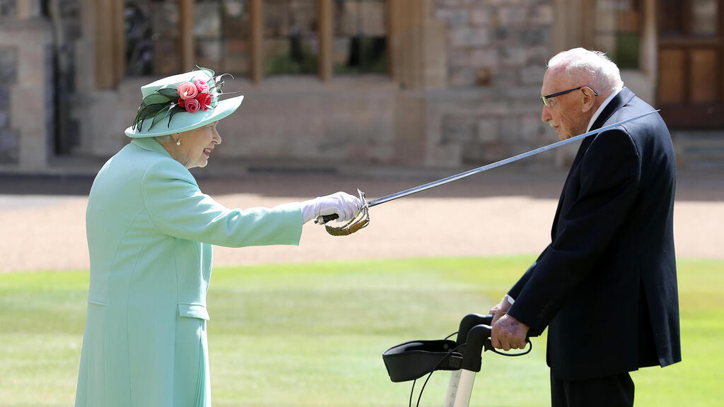 Queen Elizabeth II awards Captain Sir Thomas Moore with the insignia of Knight Bachelor 