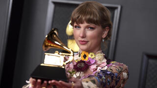 Taylor Swift poses in the press room with the award for album of the year for "Folklore" at the 63rd annual Grammy Awards at the Los Angeles Convention Center 