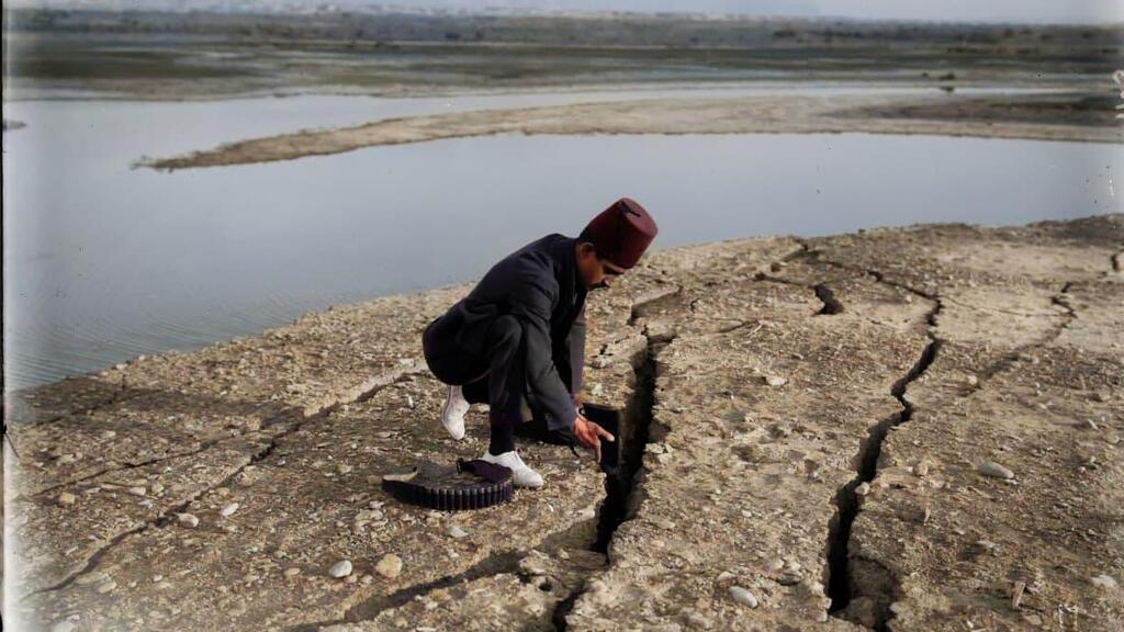 A man examines the earth that cracked in the Dead Sea as a result of the July 11, 1927 earthquake (Photo:: MyHeritage) אדם בוחן את האדמה שנבקעה בים המלח כתוצאה מהרעש 11 ביולי 1927
