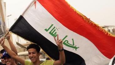Followers of Shiite cleric Muqtada al-Sadr hold posters with his photo as they celebrate the passing of a law criminalizing the normalization of ties with Israel, in Tahrir Square, Baghdad, Iraq, May 26, 2022