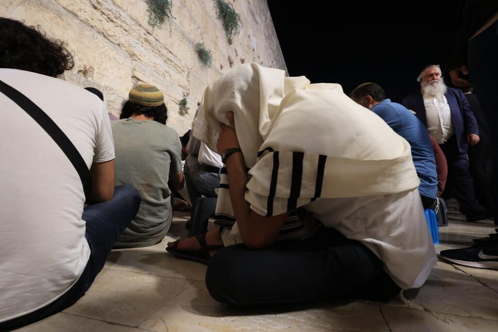Reciting the Book of Lametations at the Western Wall on Tisha B'Av (Photo: Western Wall Foundation) "איכה ישבה בדד"