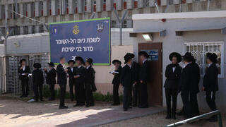 Ultra-Orthodox men outside an IDF recruitment office 