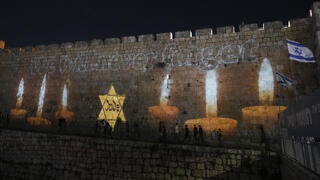 נרות זיכרון מוקרנים על חומות העיר העתיקה בירושלים