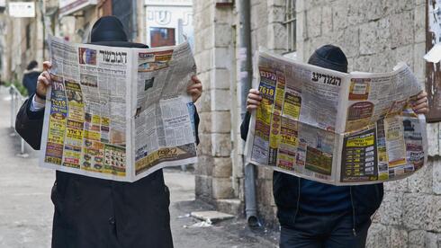 חרדים קוראים בעיתון במשפחה והמודיע 