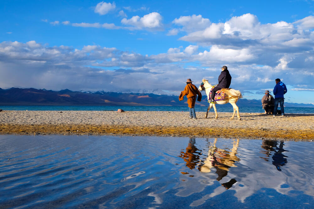 אנשי הקהילה הטיבטית חולפים בסמוך לאחד האגמים