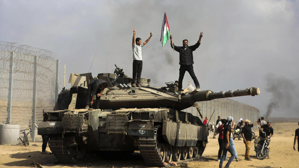Нападение ХАМАСа 7 октября 2023 года (Фото: AP Photo/Yousef Masoud) המחבלים צוהלים על גבי טנק של צה"ל