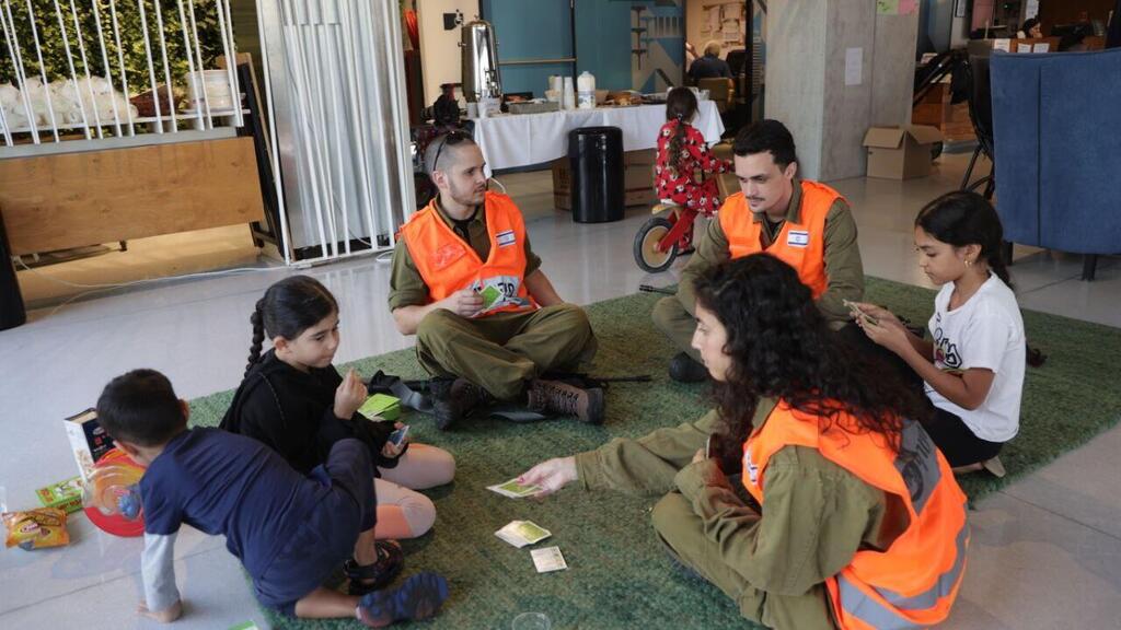 Эвакуированные из Сдерота дети с бойцами Службы тыла в Тель-Авиве, октябрь 2023 года (Фото: Моти Кимхи) מפונים משדרות בתל אביב