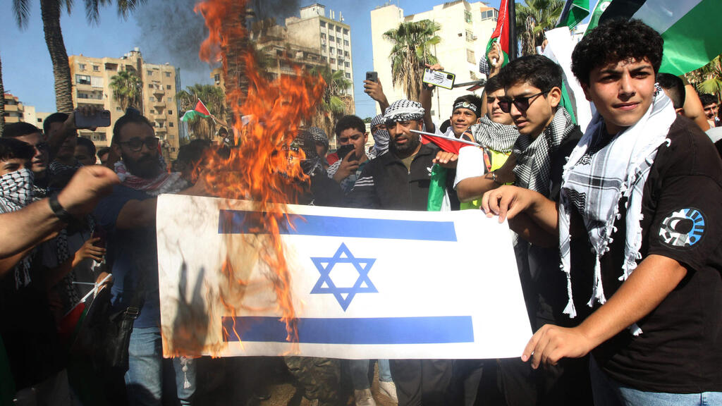 South Lebanon protesters burn Israeli flag (Photo: Mahmoud ZAYYAT / AFP) הפגנות דרום לבנון שורפים דגל ישראל