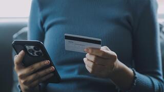 אישה עם טלפון וכרטיס אשראי