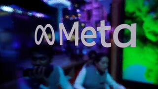 People seen behind Meta logo 