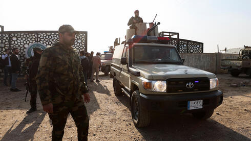 חמושים ב מיליציה מיליציות פרו-איראניות ליד  המטה שלהם ב בגדד עיראק שהופצץ