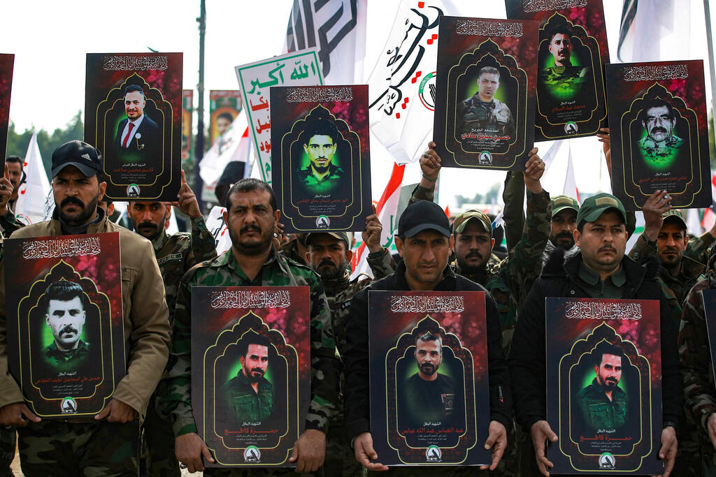 Fighters from the Shiite militia Popular Mobilization Forces in military uniform hold portraits of comrades killed in US airstrikes, during a memorial march in Baghdad, Iraq (Photo: AHMAD AL-RUBAYE / AFP) לוחמים ב מיליציה שיעית אל-חשד א-שעבי ב בגדד עיראק נושאים תמונות של פעילים שנהרגו בתקיפה של ארה"ב