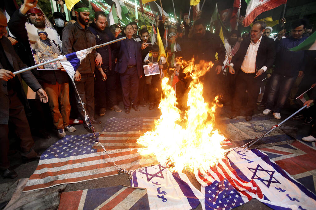 Protesters burning US and Israeli flags in Tehran, Iran (Photo: AFP) איראנים שורפים דגלים של ארה"ב וישראל בכיכר פלסטין בטהרן, איראן