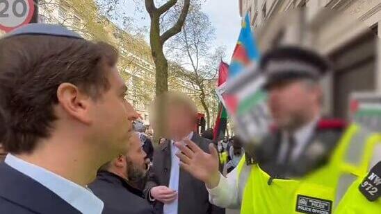 בריטניה הפגנה פרו פלסטינית שוטר מונע מ יהודי לחצות כביש כי הוא יהודי בגלוי עם כיפה