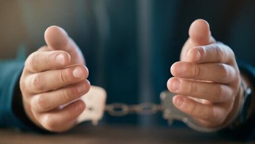 Задержанный в наручниках (Фото: shutterstock) Задержанный в наручниках