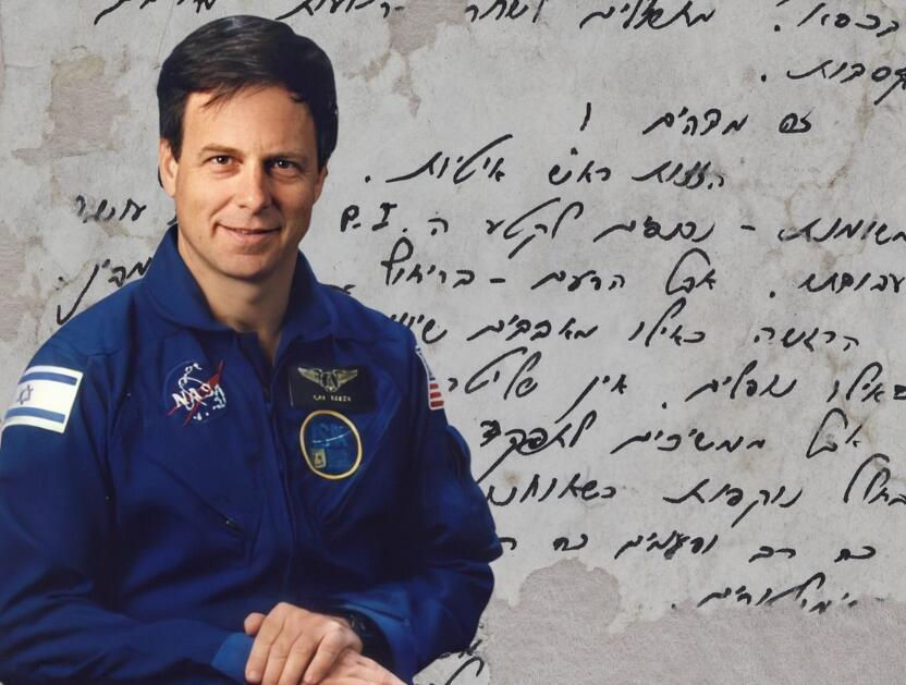 Ilan Ramon with one of the surviving pages from his diary in the background (Photo: NASA, National Library of Israel) אילן רמון על רקע אחד מדפי היומן ששרדו