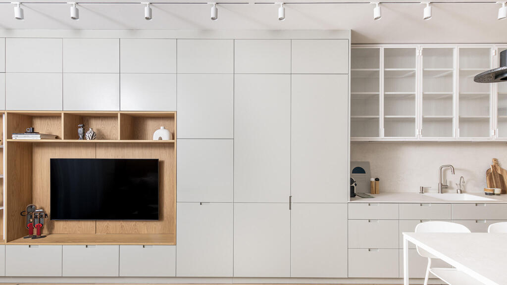 XSME - Storage. Continuous carpentry unit combining a TV unit and kitchen - a project in lieu of a hotel. Design: Sharon Cooper (Photo: Ariel Medina) XSME - אחסון. יחידת נגרות המשכית המשלבת יחידת טלויזיה ומטבח - פרויקט במקום בית מלון. עיצוב: שרון קופר