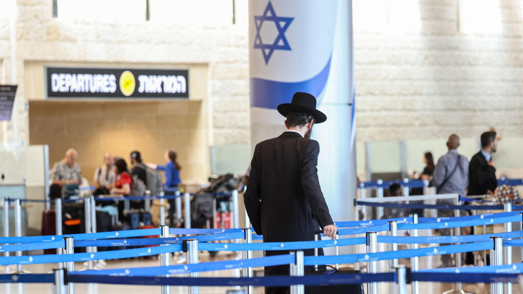Concerns over 'loopholes' in enforcement of the ban on leaving Israel (Photo: GIL COHEN-MAGEN / AFP) נוסע חרדי בשדה התעופה נתב"ג, עת היערכות לתקיפה איראנית