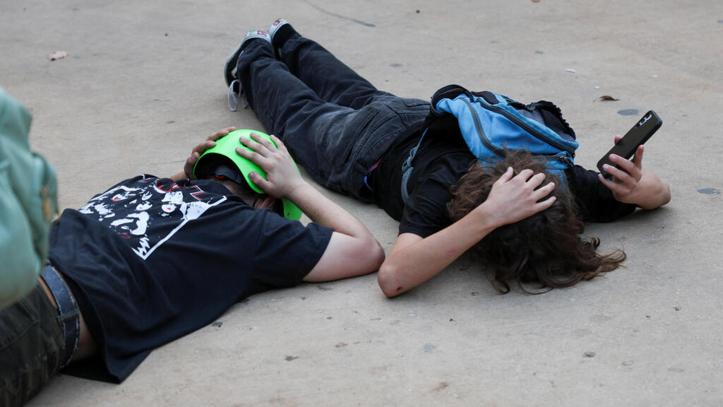 Children taking cover during rocket siren in Tel Aviv (Photo: Reuters/Violeta Santos Moura) אזעקות בתל אביב