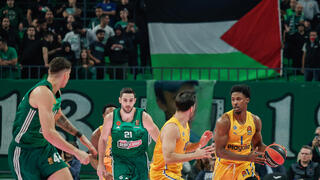 שחקני מכבי ת"א ופנאתינייקוס על רקע דגל פלסטין