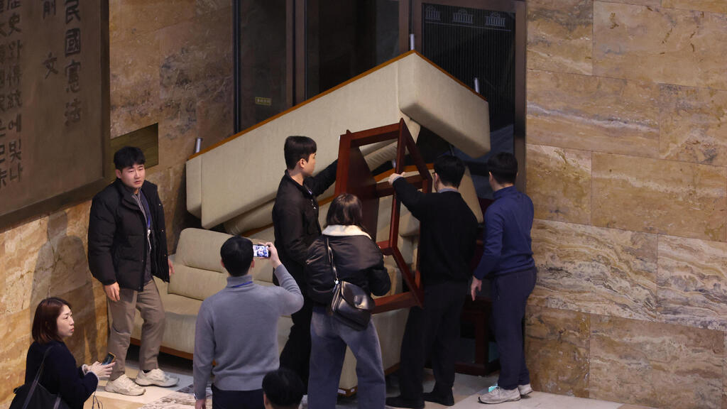 Opposition lawmakers try to block soldiers inside the parliament building on the dramatic night in early December 2024 (Photo: Yonhap via REUTERS) צוות מפלגת אופוזיציה דרום קוריאה הציבו מחסום כדי לחסום חיילים ב בניין האספה הלאומית אחרי הכרזה על משטר צבאי ברחבי המדינה סיאול
