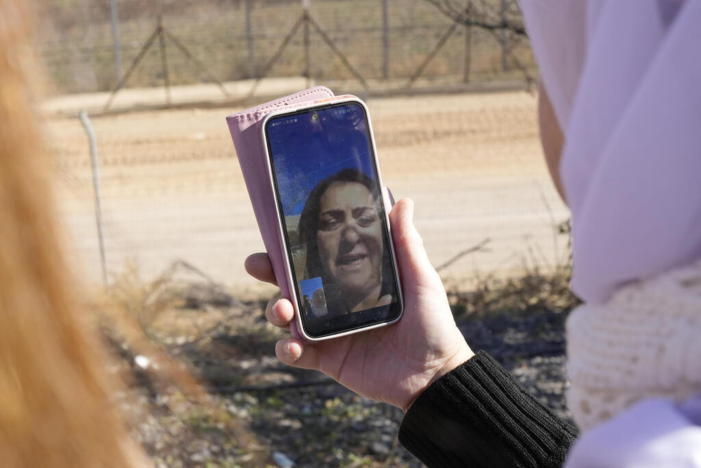 Samar Safadi holds her phone as she talks by video call with her sister, Sawsan (Photo: Matias Delacroix / AP) Samar Safadi holds her phone as she talks by video call with her sister, Sawsan