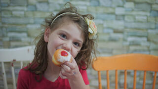 ילדה אוכלת סופגנייה חנוכה