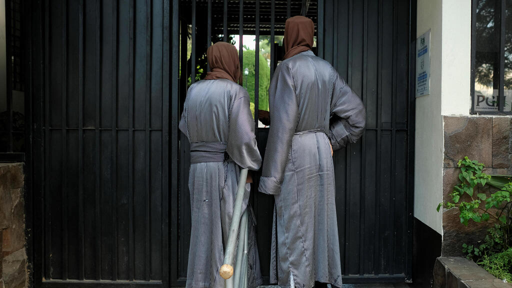 Two women standing near building belonging to the sect (Photo: Reuters) שתי נשים בכניסה לאחד המבנים בכת