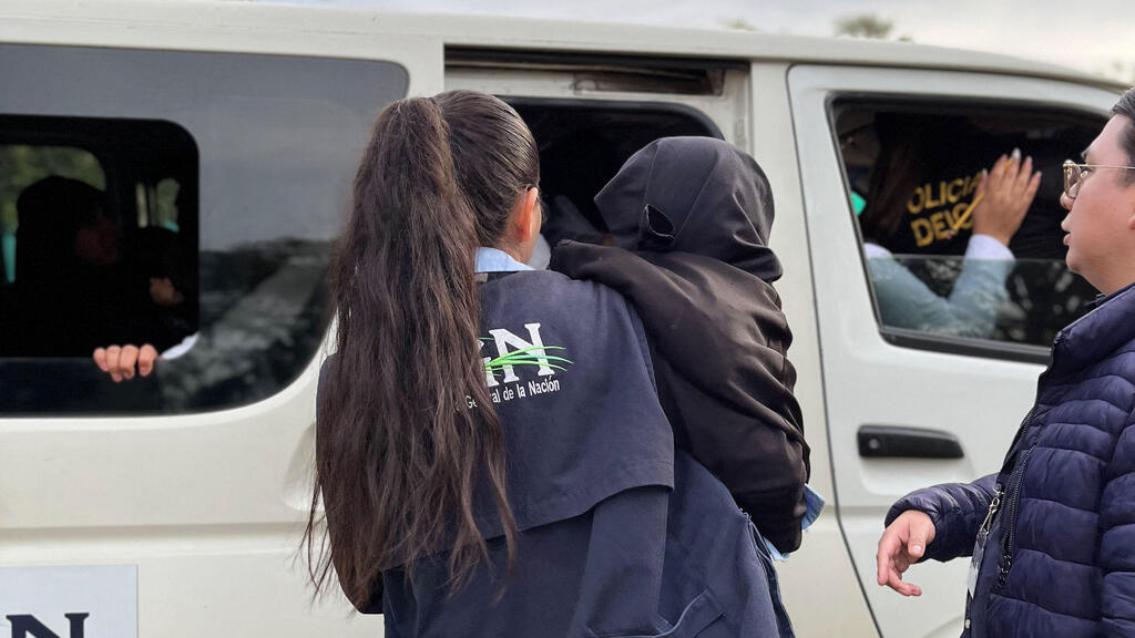 Photo: Guatemalan Attorney General of the Nation's Office \ AFP אשת כוחות הביטחון מחלצת את אחד הילדים