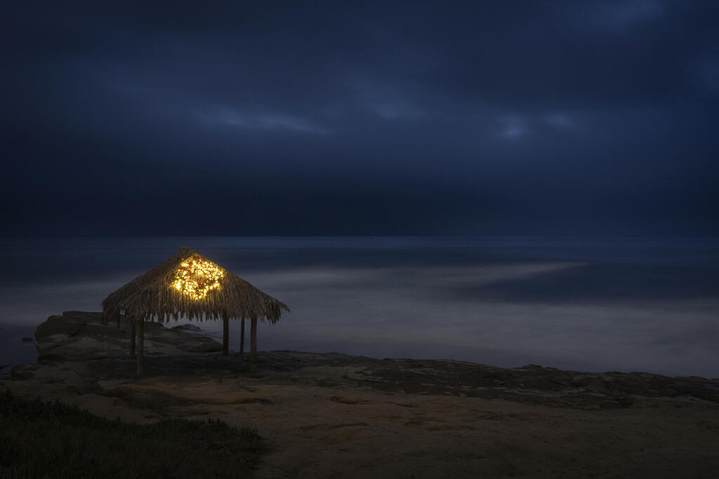 A Christmas wreath and lights adorn the surf shack at Windansea Beach in San Diego (Photo: Gregory Bull/AP) זר חג מולד ואורות מקשטים את בקתת הגלישה בחוף ווינדנסי שבסן דייגו