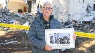 שי חרמש עם תמונה שלו מהכותל המערבי במלחמת ששת הימים, שהיתה תלויה בביתו