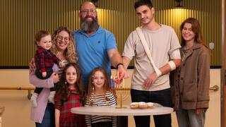 משה בכר ונדב אליקים מדליקים חנוכייה עם משפחותיהם