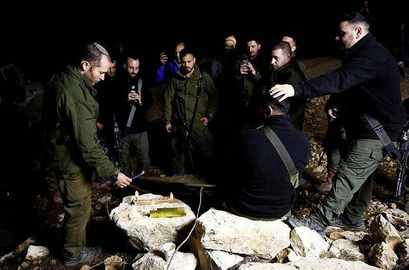 An Israeli soldier lights candles as soldiers gather to celebrate the first day of Hanukkah, near the Israeli-Lebanon border in 2024 (Photo: Shir Torem/ Reuters) An Israeli soldier lights candles as soldiers gather to celebrate the first day of Hanukkah, near the Israeli-Lebanon border
