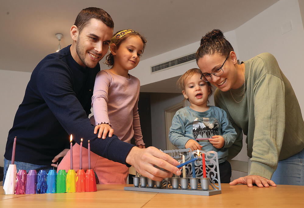 Lt. Col. Yehuda Shalev lights Hanukkah candles with his family, about two months after being wounded (Photo: Elad Gershgorn) yk14202720