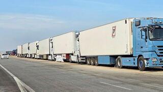 שורות של משאיות ב גבול רצועת עזה ממתינים להסכם